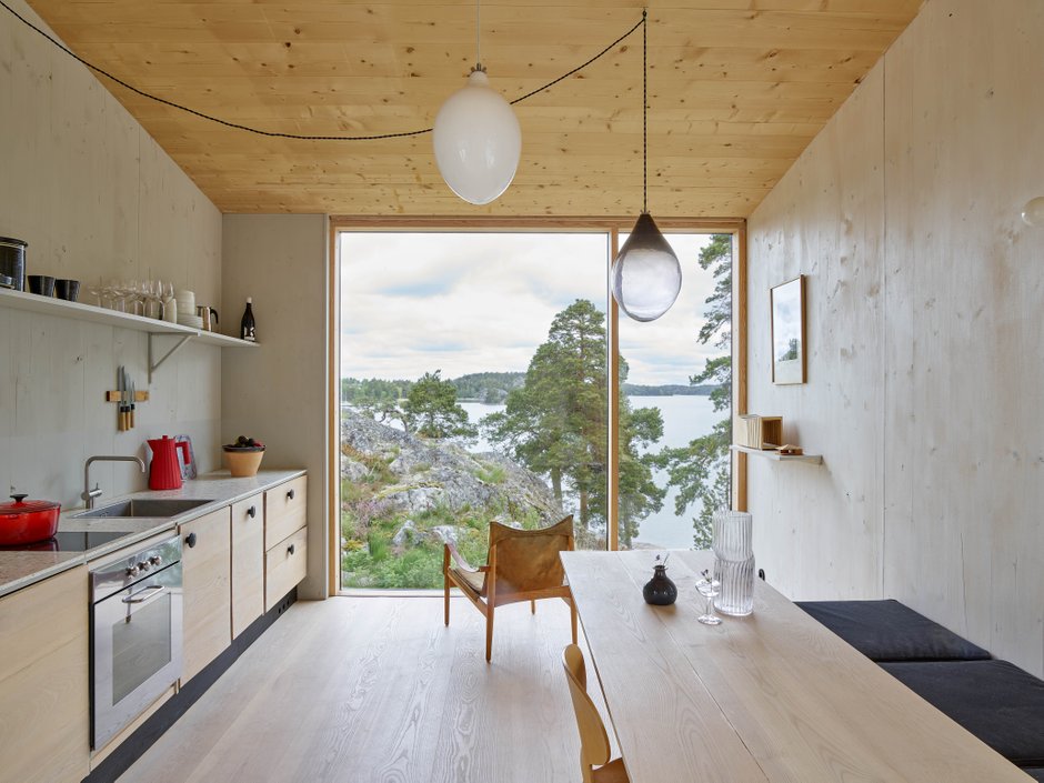 Interior of swedish summer house with a large window framing the view of the surrounding archipelago