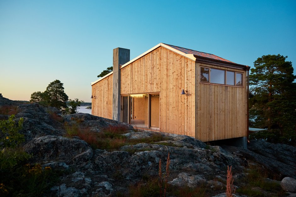 wooden house on a cliff in the stockholm archipelago some hours before sunset