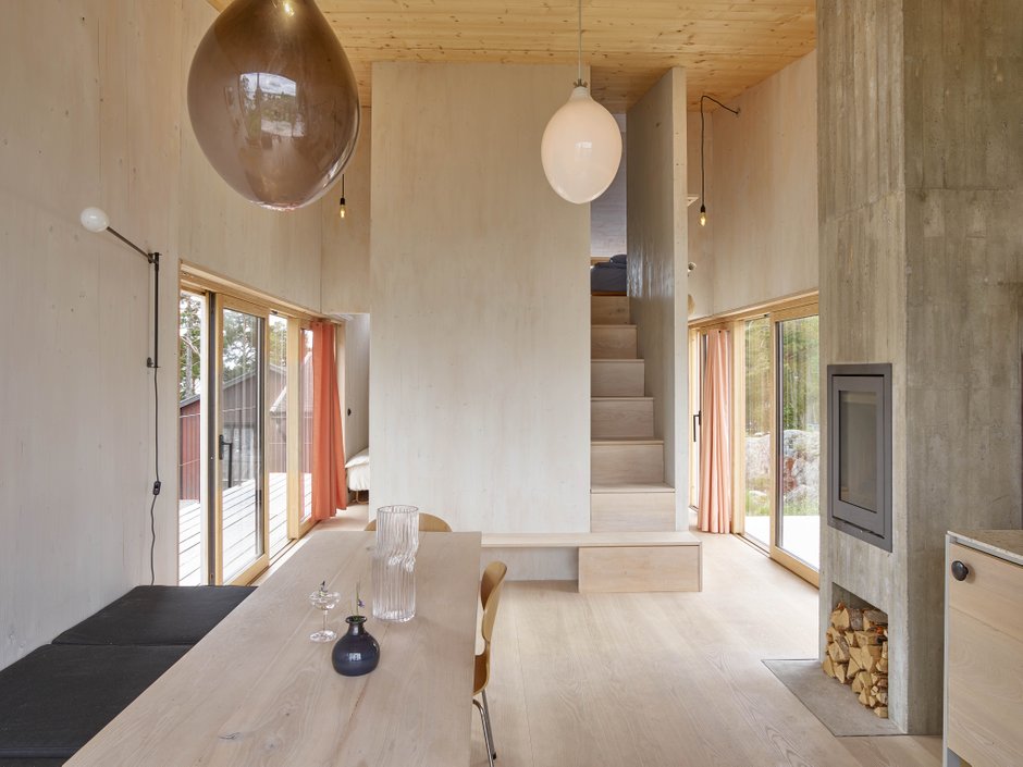 Interior of  a clt house with wooden walls painted white, a ash floor from Dinesen and lamps in glass blown by Simon Klenell